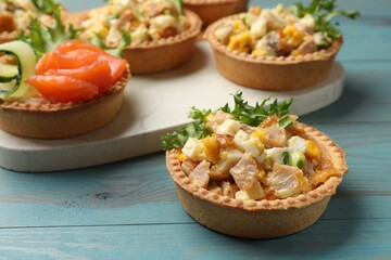 Tartlets with delicious fillings on blue wooden table, closeup