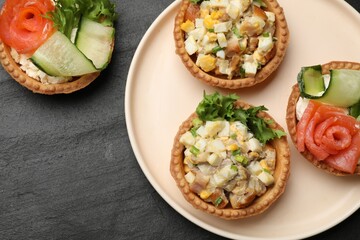 Tartlets with delicious fillings on black table, top view
