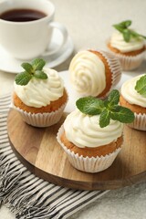Delicious carrot cupcakes with mint and coffee on light textured table, closeup