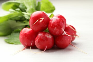 Bunch of fresh radishes on white wooden table, closeup