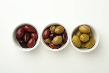 Tasty marinated olives in bowls on white table, flat lay