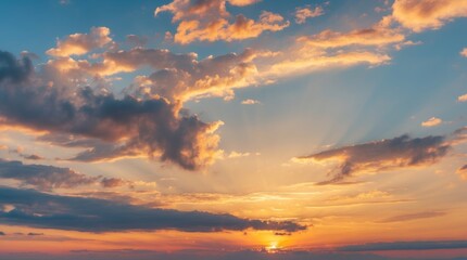 Obraz premium Vibrant sunset sky with colorful clouds and radiant rays illuminating the horizon creating a stunning natural landscape background.
