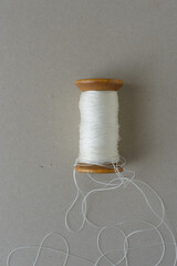 vintage wooden spool with nylon thread on cardboard