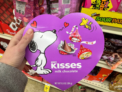 Fairfax, Virginia - February 1, 2025: Hand holds a box of Snoopy peanuts themed Hersey Kisses for Valentine's Day
