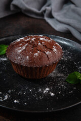 Chocolate Muffin with Powdered Sugar and Mint Garnish