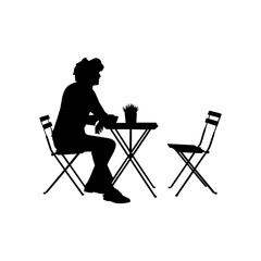 A boy is sitting on a chair, with a table in front and an empty chair next to it vector