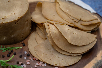 Vegan meat alternative: seitan ham sliced on wooden board