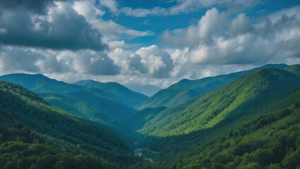 Mountain landscape with lush green hills and cloudy blue sky in the background featuring layers of mountains and valleys Copy Space