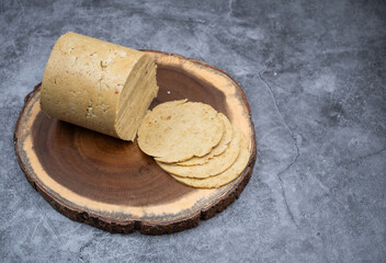 Vegan ham made in ham mold, sliced, wooden board. Mock vegan meat as plant based alternative to meat.