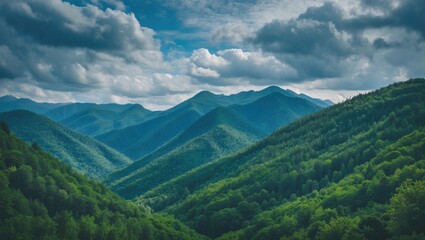Obraz premium Mountain landscape with lush green valleys and cloudy blue sky in the background showcasing natural scenery and outdoor beauty Copy Space