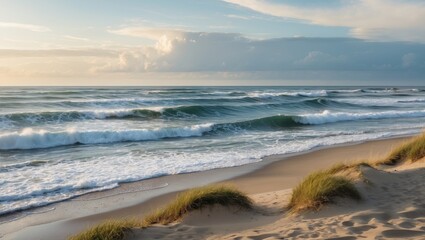 Ocean waves crashing on sandy beach at sunset with grass in the foreground and clouds in the sky Copy Space