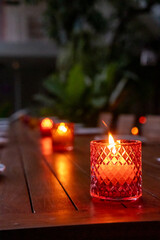 Candle in colorful glass, on the table in the outdoor restaurant