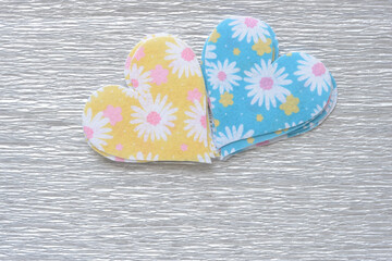 pile of felt hearts with floral patterns on silvery crepe paper