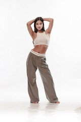 Fototapeta premium Young girl in trousers posing on a white background
