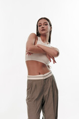 Fototapeta premium Young girl in trousers posing on a white background