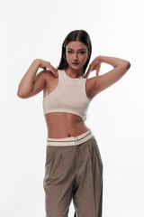 Fototapeta premium Young girl in trousers posing on a white background