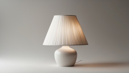 White table lamp with pleated shade on neutral background with soft lighting and copy space for text.