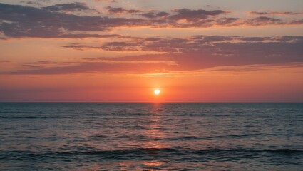 Obraz premium Dramatic sunset over calm ocean water with colorful sky and gentle waves reflecting light Copy Space