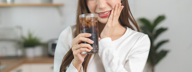 Health asian young woman touching her mouth, expression, suffering from toothache, decay or sensitivity cavity molar tooth or inflammation drink cold, sparkling water at home.Sensitive teeth people.