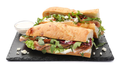 Halves of baguette sandwich with prosciutto and sun dried tomatoes isolated on white