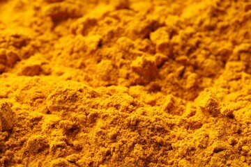Aromatic turmeric powder as background, closeup view