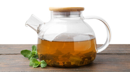 Aromatic mint tea in glass teapot and fresh leaves on wooden table against white background