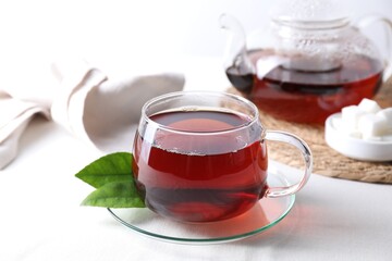 Refreshing black tea in cup on light table