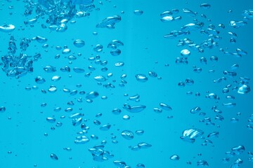 Many water bubbles on blue background, closeup
