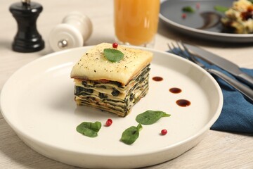 Piece of tasty spinach lasagna on wooden table, closeup