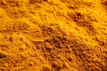 Aromatic turmeric powder as background, closeup view