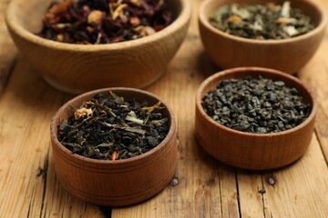 Different types of tea brew on wooden table, closeup