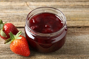 Delicious strawberry sauce and fresh berries on wooden table, closeup