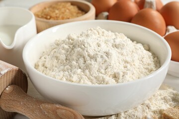Ingredients for dough and rolling pin on table, closeup