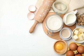Rolling pin and different ingredients on white table, flat lay. Space for text