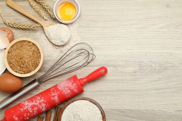 Rolling pin and different ingredients on light wooden table, flat lay. Space for text