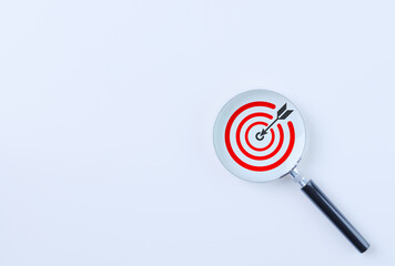 Business goal strategy and target concept. Magnifying glass focusing on red target with arrow dart...