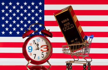 Gold bar in miniature supermarket shopping cart with USA flag background