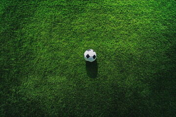 Obraz premium Soccer ball positioned on a fresh green soccer field, with the vibrant turf creating a sharp contrast, ready for the match to begin.