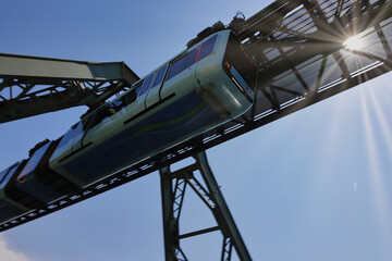 Wuppertal, die Schwebebahn rauscht im Sonnenschein über die Wupper hinweg