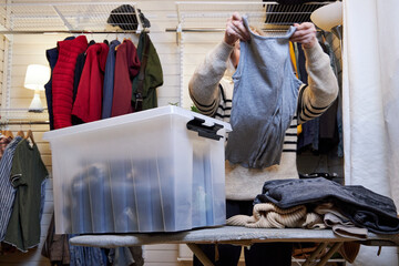 a woman puts clothes in a box, the concept of organizing order in the house
