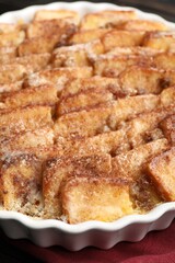 Delicious bread pudding with raisins and cinnamon on table, closeup