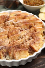 Delicious bread pudding with raisins and cinnamon on wooden table, closeup