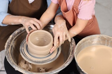 Hobby and craft. Mother with her daughter making pottery indoors, closeup