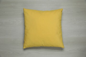One decorative pillow on wooden background, top view
