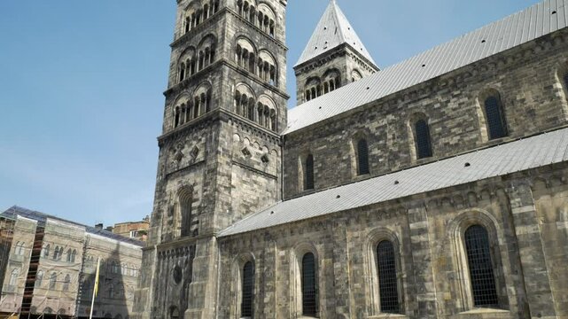 Majest&auml;tischer Blick nach oben auf den Dom zu Lund &ndash; imposante romanische Architektur mit historischen T&uuml;rmen und faszinierenden Details vor schwedischem Himmel
