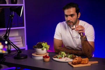 Healthy influencer in host channel presenting fresh vegetables in special dish of salad with brest...