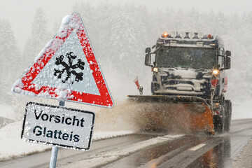 Vor einem Fahrzeug für Winterdienst und Schneeräumung steht ein Verkehrsschild und warnt vor...
