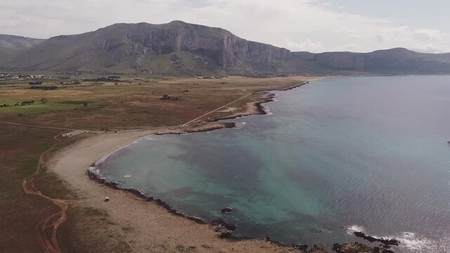 Aerial drone view of Macari (Makari), Sicily. Crystal clear turquoise waters, rugged cliffs, golden sandy beaches. A serene natural landscape with Mediterranean charm near San Vito lo Capo.	
