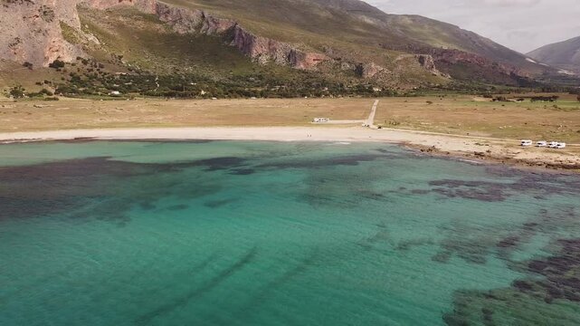 Aerial drone view of Macari (Makari), Sicily. Crystal clear turquoise waters, rugged cliffs, golden sandy beaches. A serene natural landscape with Mediterranean charm near San Vito lo Capo.	