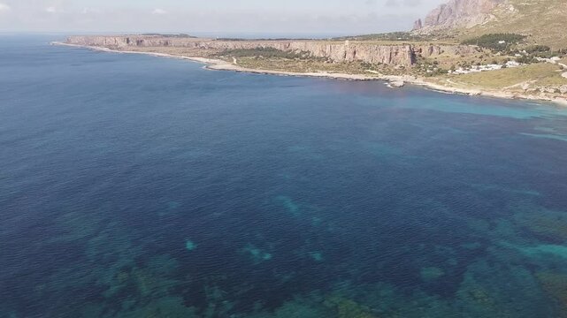 Aerial drone view of Macari (Makari), Sicily. Crystal clear turquoise waters, rugged cliffs, golden sandy beaches. A serene natural landscape with Mediterranean charm near San Vito lo Capo.	
